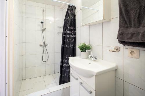 a small bathroom with a sink and a shower at Saint Pauls Apartments in Antwerp