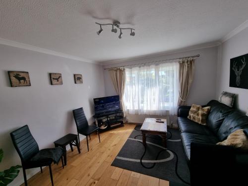 a living room with a couch and chairs and a table at 168 - ExcellentStays - 2 Bedroom Flat in Stanwell