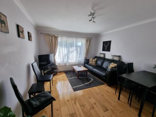 a living room with a couch and a table at 168 - ExcellentStays - 2 Bedroom Flat in Stanwell