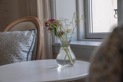 a vase filled with flowers sitting on a table at Sandkaas Badehotel in Allinge