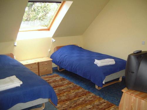 a bedroom with two beds and a tv in it at Laugu Guesthouse in Kuusalu