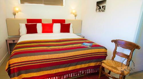 a bedroom with a bed with a colorful blanket and a chair at Casona Granado in El Pilar y Provincias