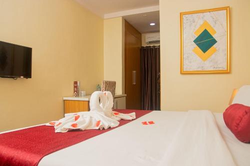 a room with a bed with a stuffed animal on it at Chateux De Atlantique Hotel in Lagos