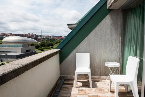 two white chairs and a table on a balcony at Hotel Palacio del Mar in Santander