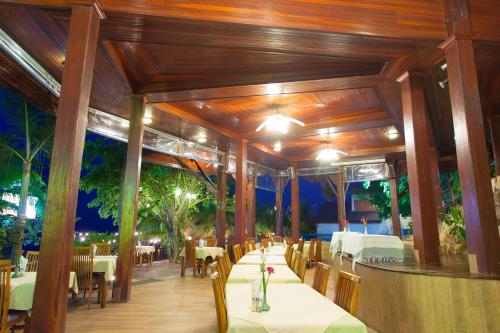 a restaurant with wooden ceilings and tables and chairs at Haad Yao Bayview Resort & Spa - SHA plus Certified in Haad Yao