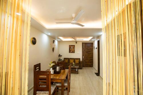 a dining room with a table and a couch at Yogvan Luxury 1BHK Apartments Tapovan Rishikesh in Rishīkesh