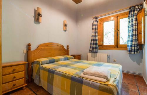 a small bedroom with a bed and a window at Casas Rurales Los Enebros Nerpio in Nerpio