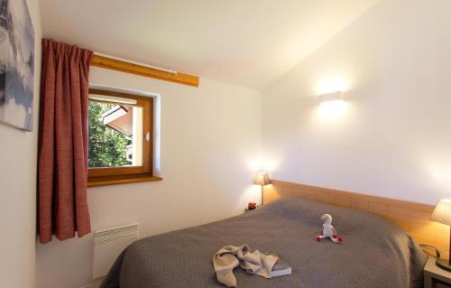 a bedroom with a bed with two towels on it at Résidence Odalys Le Buet in Morillon