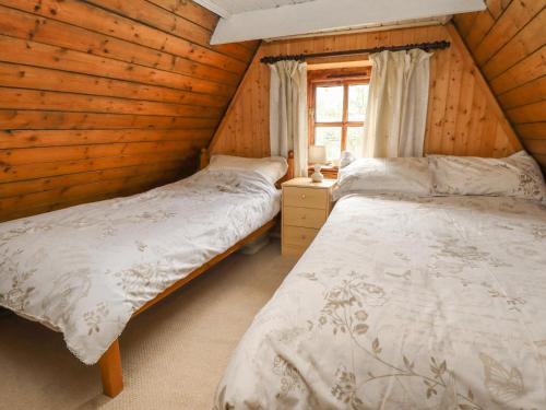 2 letti in una camera in legno con finestra di Woldsend Cottage a Horncastle