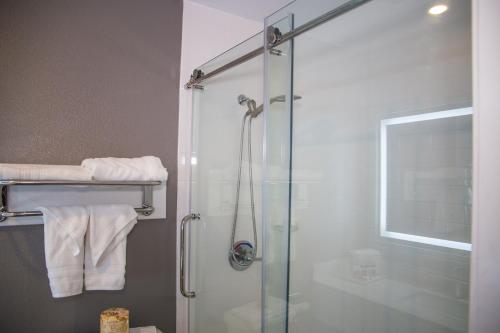 a bathroom with a glass shower with white towels at Days Inn by Wyndham Redwood City in Redwood City