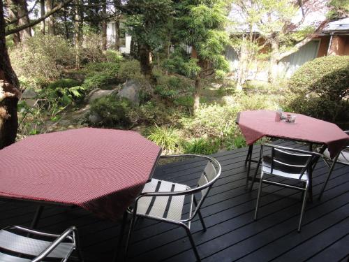 a patio with two tables and chairs on a deck at Oimatsuen in Saku