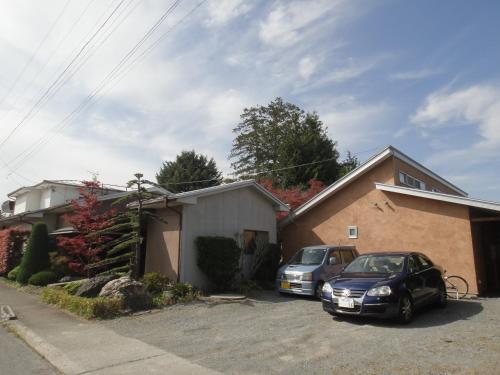 two cars parked in a driveway next to a house at Oimatsuen in Saku