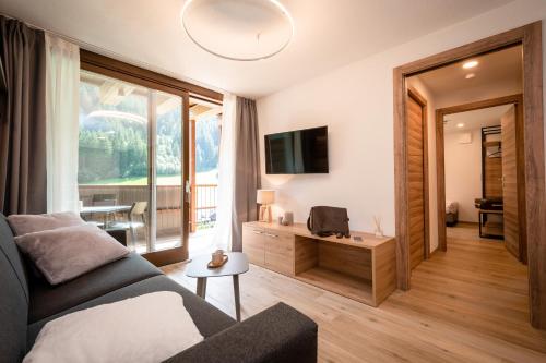 a living room with a couch and a large window at Nira Mountain Resort Futura in Valdidentro