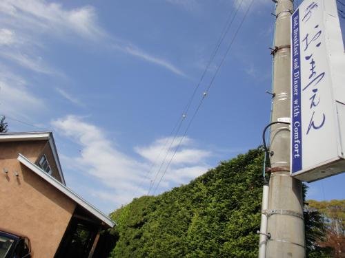 a street sign on a pole in front of a mountain at Oimatsuen in Saku