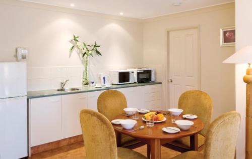 cocina y comedor con mesa y sillas en Royal Woods Resort, en Gold Coast