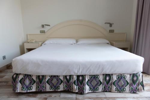 a bedroom with a large bed with a white mattress at Hotel Palacio del Mar in Santander