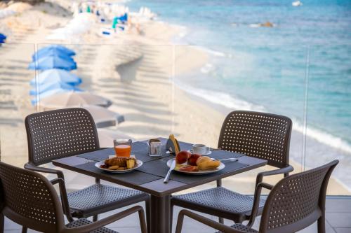 Villaggio Tramonto في كابو فاتيكانو: طاولة مع صحن فاكهة وإطلالة على الشاطئ