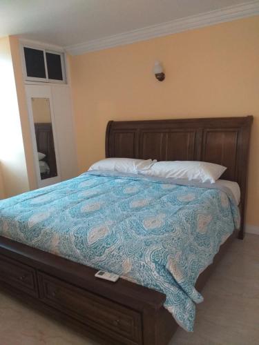a bedroom with a bed with a blue comforter at Rooms By the Pool in Kingston