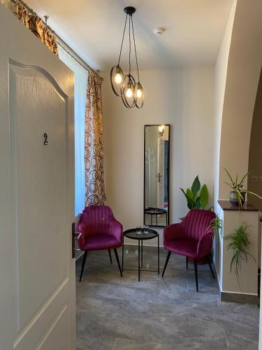 a hallway with two red chairs and a table at Boutique Rooms with Parking in Oradea