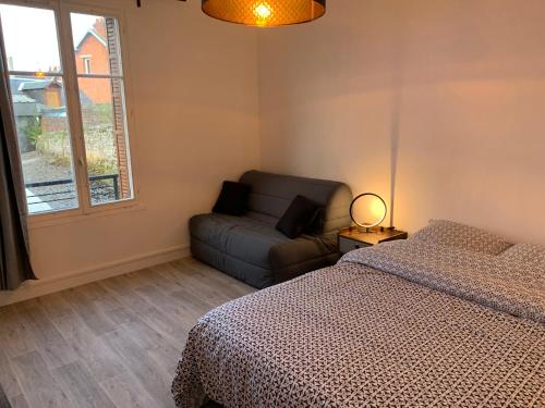 a bedroom with a bed and a couch and a window at Le famillial , 2 chambres, 4 lits double Avec parking PRIVE 1 VOITURE, NETFLIX, DISNEY PLUS DISPONIBLE in Dieppe