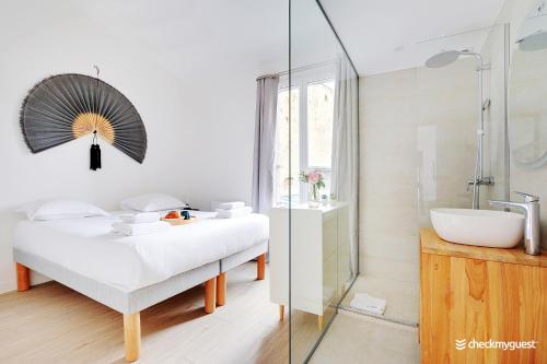 La salle de bains est pourvue d'un lit, d'un lavabo et d'une douche. dans l'établissement Beautiful apartment- 3BR-10P - Montparnasse, à Paris