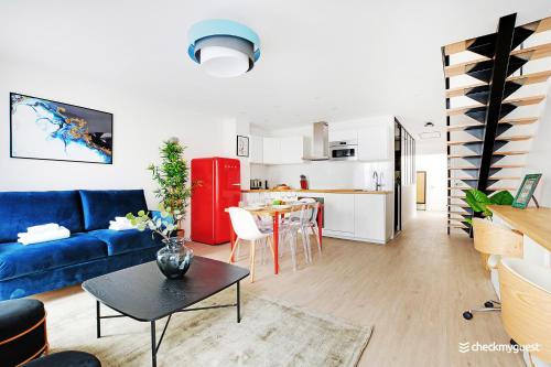 un salon avec un canapé bleu et une cuisine dans l'établissement Beautiful apartment- 3BR-10P - Montparnasse, à Paris
