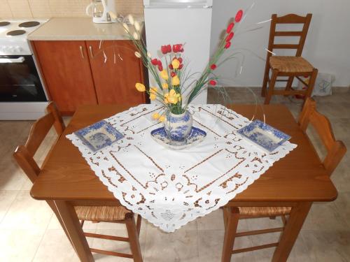 a table with a vase of flowers on it at Chrysolithos Kerami Apartments in Khalkíon
