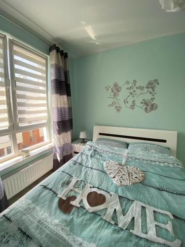 Un dormitorio con una cama con la palabra ejército. en Przytulny apartament niedaleko centrum, en Szczecin
