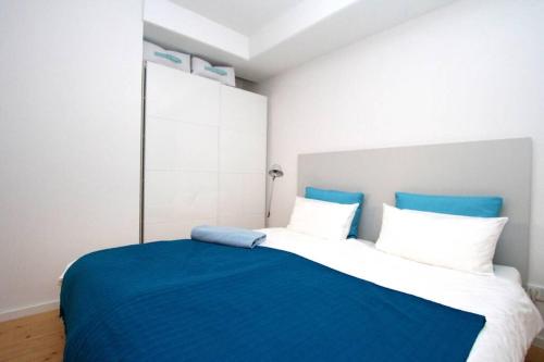 a bedroom with a blue and white bed with white pillows at Modern & Friendly Apartment Ammersee in Windach
