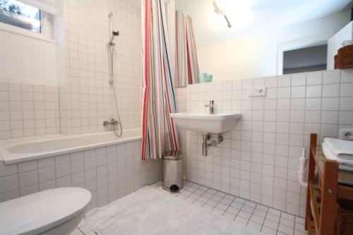 a bathroom with a sink and a toilet and a shower at Modern & Friendly Apartment Ammersee in Windach