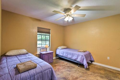 1 Schlafzimmer mit 2 Betten und einem Deckenventilator in der Unterkunft Texas Cabin on 130 Acres Walk to Lake Ray Roberts in Collinsville