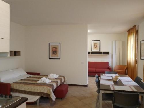 a hotel room with a bed and a red couch at Residence le Polle in Riolunato