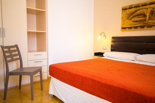 a bedroom with a bed and a chair in it at Donnosanto Residence in Torre Santa Sabina
