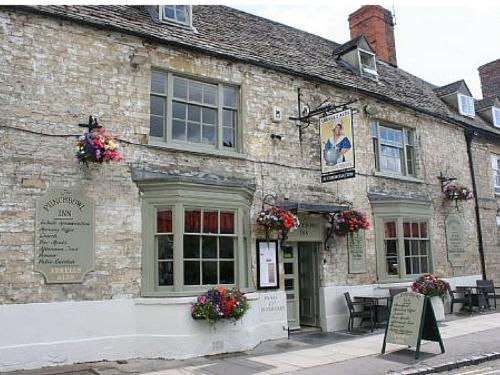 un viejo edificio de piedra con flores delante en The Punchbowl Inn, en Woodstock