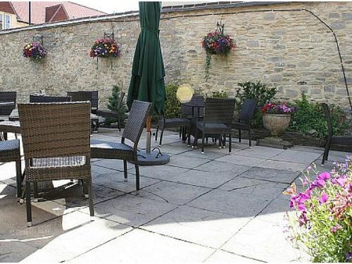 a patio with tables and chairs and an umbrella at The Punchbowl Inn in Woodstock