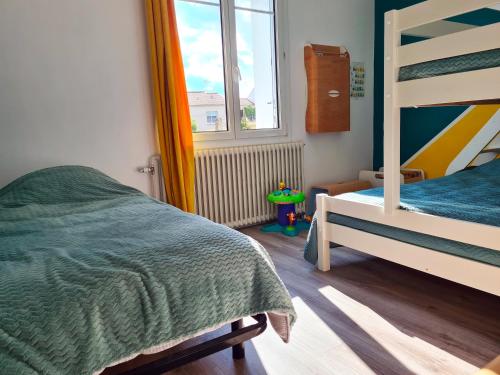 une chambre avec un lit superposé et une fenêtre dans l'établissement Puy du Fou Maison 12 personnes 4mn du Grand Parc, aux Épesses