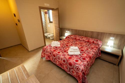 a bedroom with a red bed with towels on it at Il Tufo in Montesano sulla Marcellana