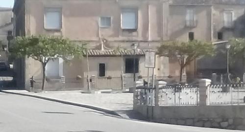 a building with a fence and two trees in front of it at Santa Caterina dello Ionio Boutique Apartments in Santa Caterina dello Ionio