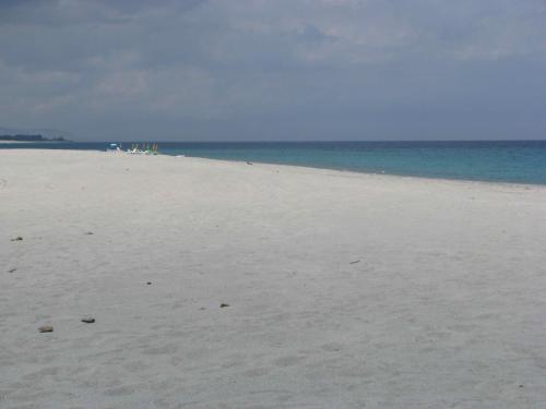 a white sandy beach with the ocean in the background at Santa Caterina dello Ionio Boutique Apartments in Santa Caterina dello Ionio