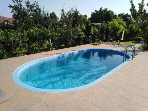 einen großen blauen Pool auf einer Terrasse mit Bäumen in der Unterkunft Vila Verona Sobe in Palić