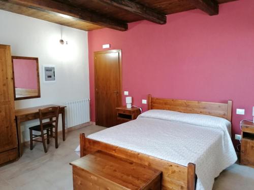 a bedroom with a bed and a table and a desk at La Rocca dei Borboni in Santa Domenica Talao