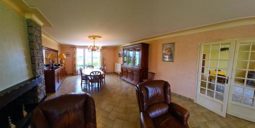 a living room with chairs and a dining room at Puy du Fou Maison 12 personnes 4mn du Grand Parc in Les Épesses