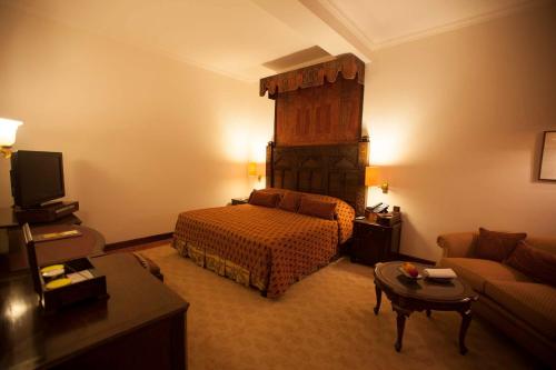 a hotel room with a bed and a couch at Islamabad Serena Hotel in Islamabad