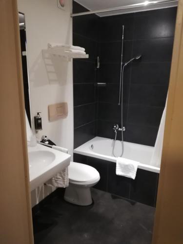 a bathroom with a toilet and a sink and a shower at Hotel Parc & Lac in Montreux