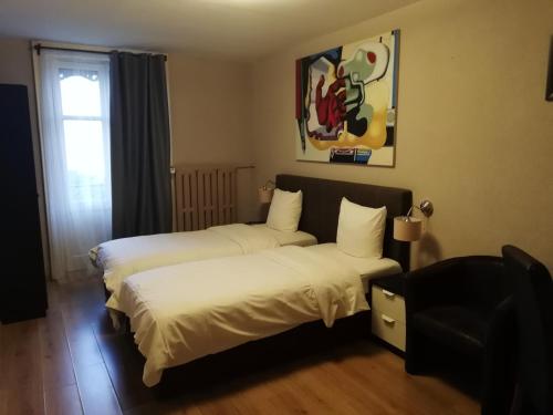 a hotel room with two beds and a chair at Hotel Parc & Lac in Montreux