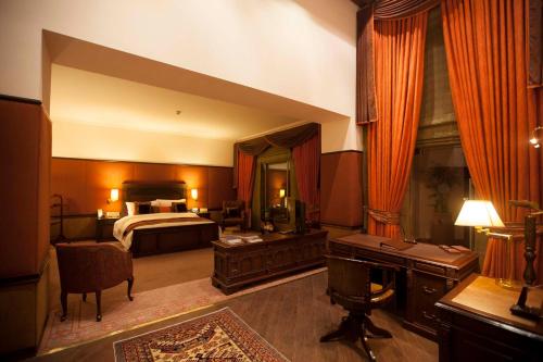 a large bedroom with a bed and a desk at Islamabad Serena Hotel in Islamabad