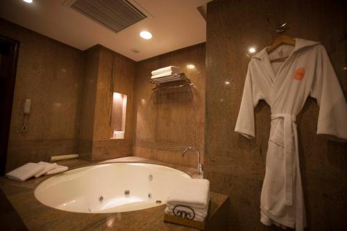 a bathroom with a bath tub and a robe at Islamabad Serena Hotel in Islamabad