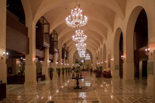 a lobby with chandeliers and a table in the middle at Islamabad Serena Hotel in Islamabad