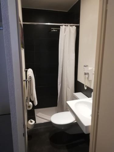 a bathroom with a white toilet and a sink at Hotel Parc & Lac in Montreux