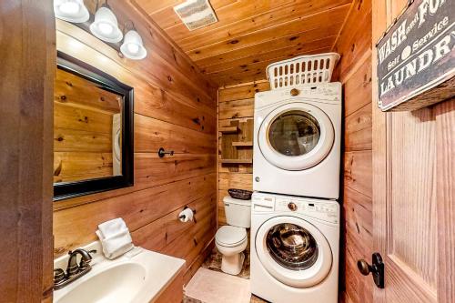 baño con lavadora y secadora en una cabaña de madera en Bear Tracks, en Pigeon Forge